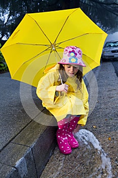 Young caucasian girl playing in the rain
