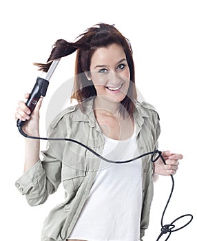 Young caucasian girl using curling iron