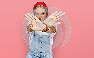 Young caucasian girl wearing casual clothes rejection expression crossing arms and palms doing negative sign, angry face