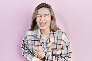 Young caucasian girl wearing casual clothes smiling and laughing hard out loud because funny crazy joke with hands on body