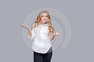 Young caucasian girl in white shirt isolated on gray background points out copy
