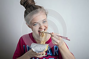 Young caucasian girl woman eating instant noodles ramen with chopsticks