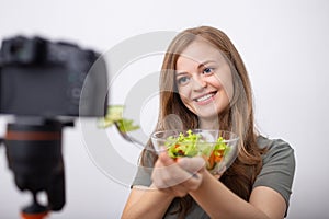 Young caucasian girl woman making a video blog vlog with camera about healthy vegetarian lifestyle