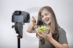 Young caucasian girl woman making a video blog vlog with camera about healthy vegetarian lifestyle