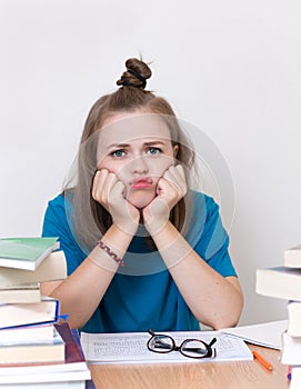 Young caucasian girl woman with many books study at school or university, looks tired, stressed or exhausted