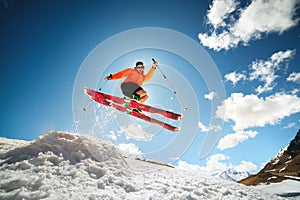 young caucasian guy jumping from a springboard on skis