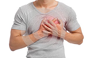 Young caucasian guy suffering from pain in chest, presses hand to sore spot, indicated in red