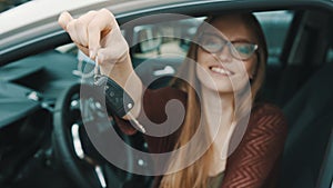 Young caucasian happy woman in front of the new car and holding keys