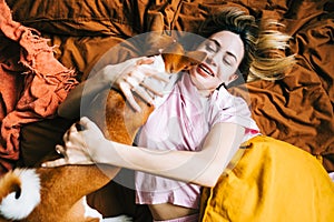 Young caucasian happy woman waking up with pet in the morning