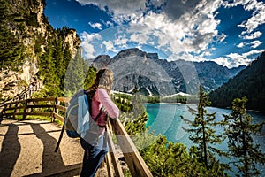 Young caucasian hiker admiring the view of Baires Lake in the Dolomite mountains, South Tirol, Italy photo