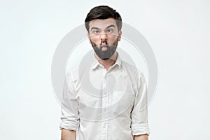 Young caucasian hipster man wearing white shirt over isolated background making fish face with lips