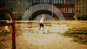 Young Caucasian Kid Playing with Ball in the Neighborhood. Young Boy Practicing Soccer Drills, Doing