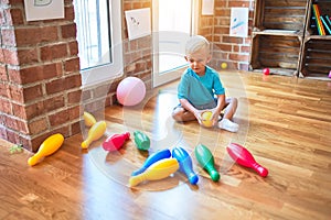 Young caucasian kid playing at kindergarten with toys. Preschooler boy happy at playroom