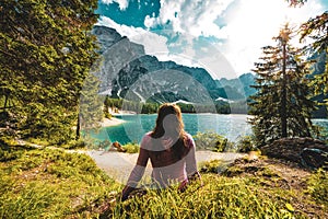 Young caucasian lady admiring the view of Baires Lake in the Dolomite mountains, South Tirol, Italy photo