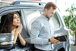 Young caucasian lady begs her husband to buy new car