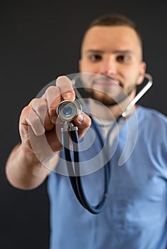 Young caucasian male doctor or nurse in blue uniform and stethoscope isolated