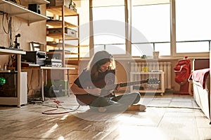 Young caucasian male play electric guitar at home