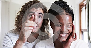 A young Caucasian man and an African American woman are smiling at the camera