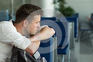 Young caucasian man at the airport waiting for his plane