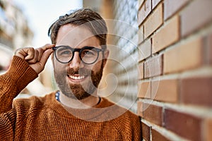 Young caucasian man with beard wearing glasses outdoors on a sunny day