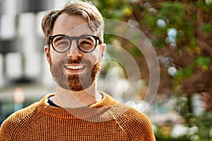 Young caucasian man with beard wearing glasses outdoors on a sunny day