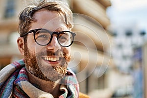 Young caucasian man with beard wearing glasses outdoors on a sunny day