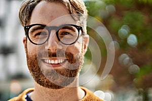 Young caucasian man with beard wearing glasses outdoors on a sunny day