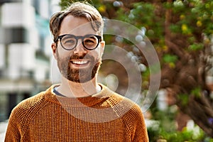 Young caucasian man with beard wearing glasses outdoors on a sunny day