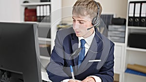 Young caucasian man business worker having video call writing notes at office