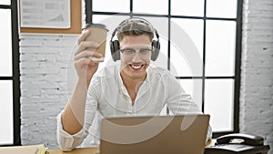 Young caucasian man business worker using laptop and headphones holding coffee at the office