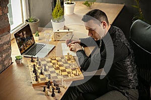 Young Caucasian man chess player playing chess online with his student.