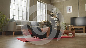 Young caucasian man doing floor push-ups at home