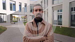 Young Caucasian man formal suit turning to camera looking serious. Confidence Businesspeople outside