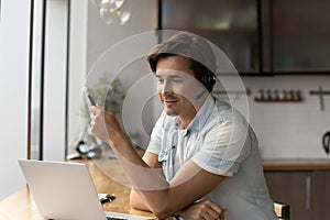 Young Caucasian man in headphones talk on webcam call