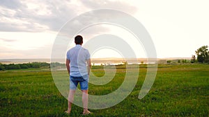 Young caucasian man looking down from the mountaine towards the river.