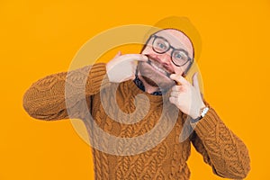 young caucasian man making a goofy face by widening his face with his own fingers