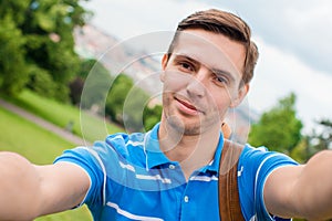 Young caucasian man making selfie background european old city by mobile phone from the observation place