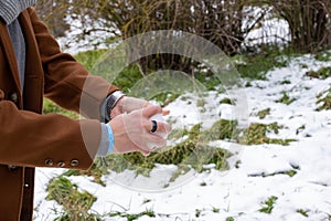Young Caucasian man making a snowball in park in Burgos. photo