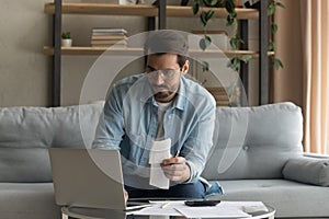 Young Caucasian man manage household finances using laptop