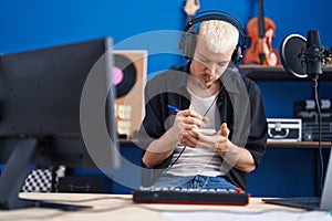 Young caucasian man musician composing song at music studio