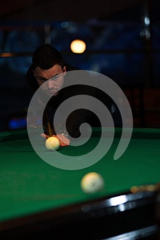 Young caucasian man playing billiard game in club