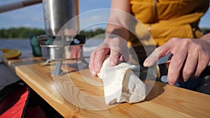 Young caucasian man preparing lunch on a inflatable boat. HD slowmotion