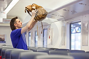 Young caucasian man putting luggage on the top