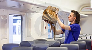 Young caucasian man putting luggage on the top