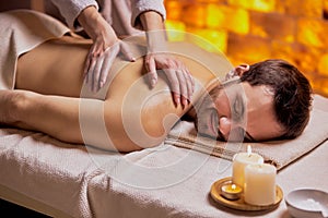 Young caucasian man receiving massage relax treatment close-up from female hands