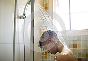 Young caucasian man showering in bathroom
