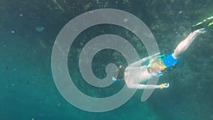 Young caucasian man with a snorkel mask and fins swims freediving underwater. Shooting with an action camera