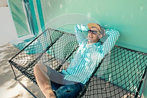 Young caucasian man swinging in a hammock pleasant laziness of weekend morning.