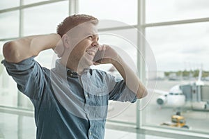 Young caucasian man talking on mobile phone at airport