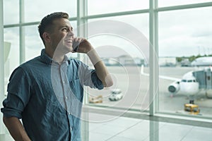 Young caucasian man talking on mobile phone at airport